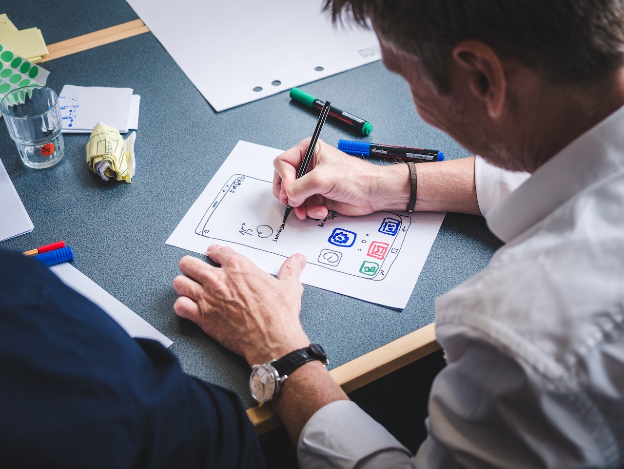 Picture of a man designing a product prototype on piece of paper